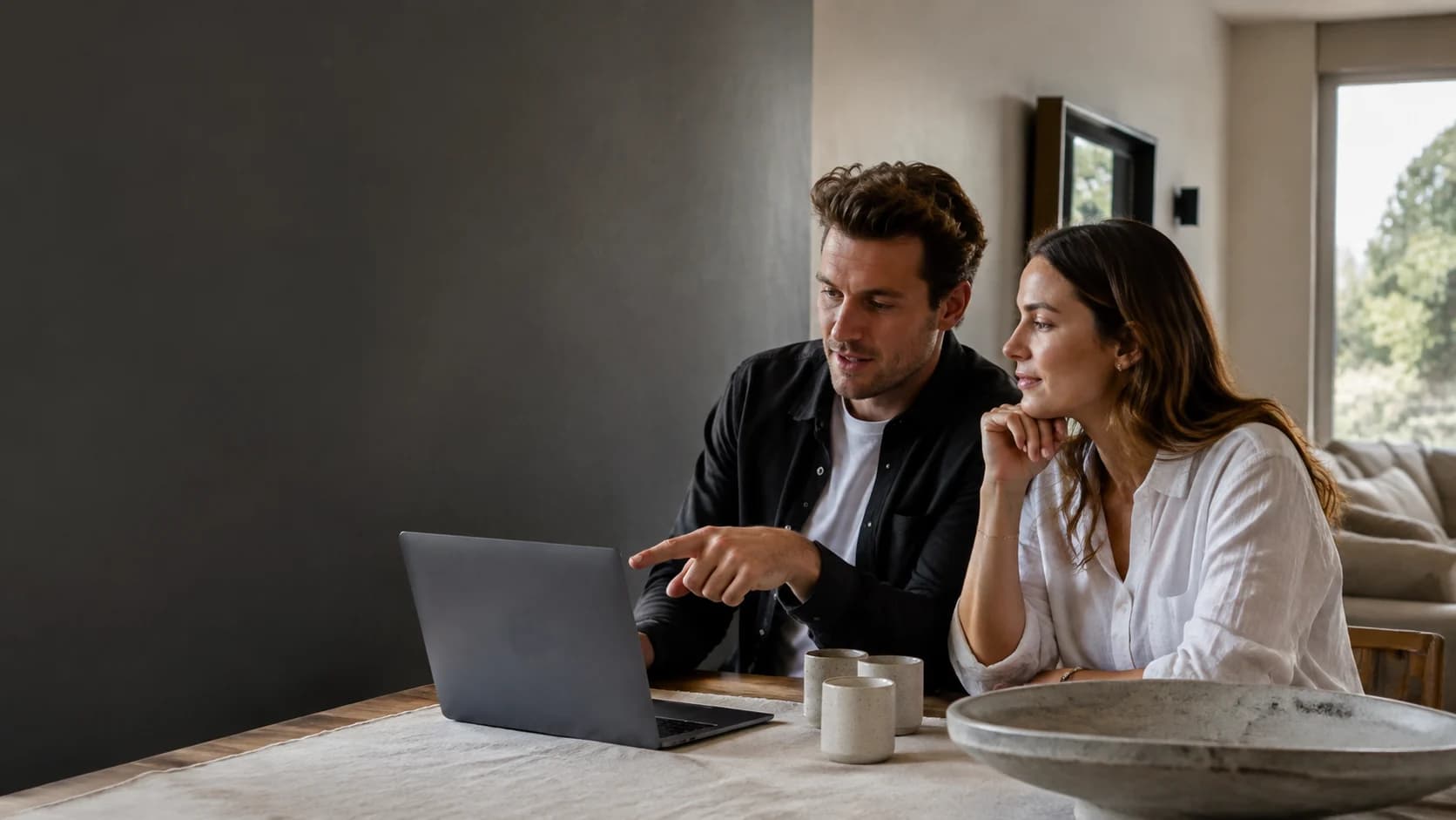 A couple reviewing an apartment listing together on a laptop
